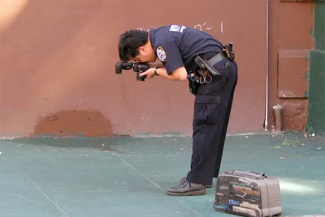 A crime scene investigator takes photographs.
